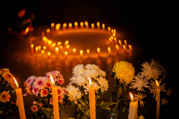 fuego sobre velas y un grupo de flores para rezar por el rey muerto
 - Foto, Imagen