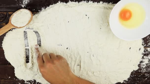 Top view Young man writes a word recipe on white flour at wooden desk from above. - Footage, Video