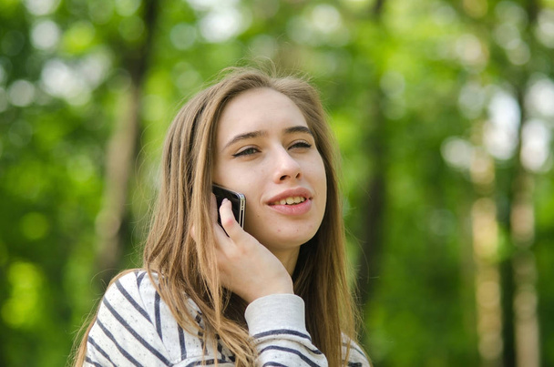Nuori nainen käyttää hänen puhelintaan - Valokuva, kuva