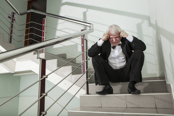 человек в смокинге на металлической лестнице
 - Фото, изображение