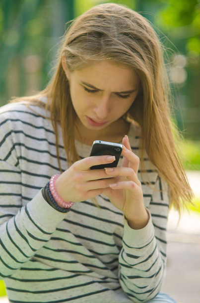 Young woman using her phone - Photo, image