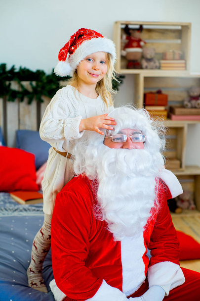 Santa Claus and cute girl getting ready for Christmas - Фото, зображення