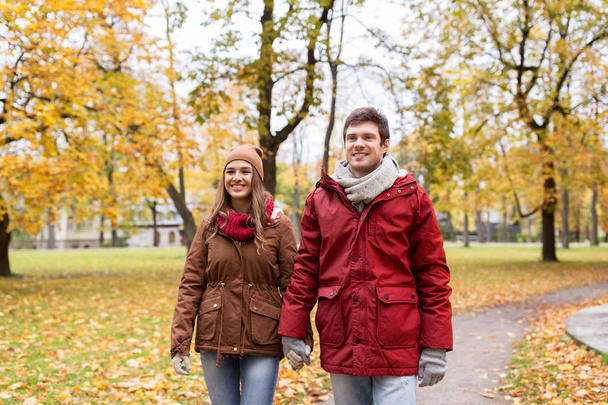 happy young couple walking in autumn park - 写真・画像
