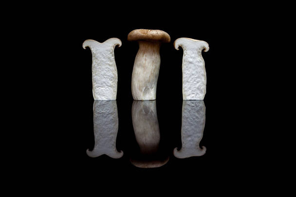 Three upright king oyster mushrooms, one whole and two halved is - Photo, Image