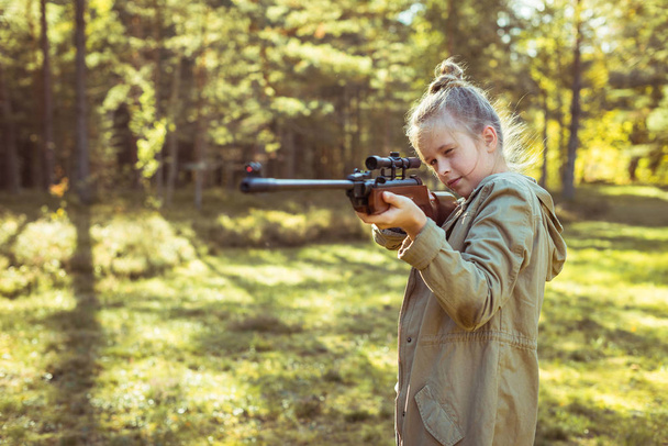 Meisje schieten uit de lucht geweer in het bos - Foto, afbeelding