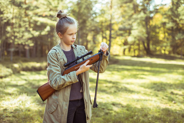 Meisje schieten uit de lucht geweer in het bos - Foto, afbeelding