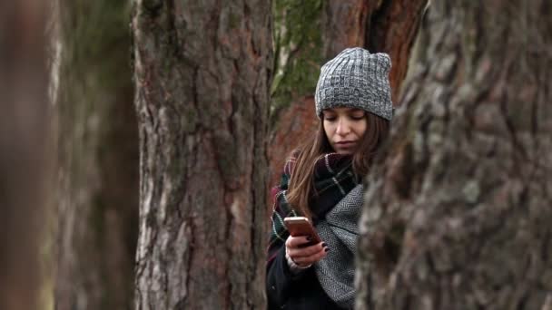 chica se sienta en un pino en un traje de protección de otoño
 - Imágenes, Vídeo