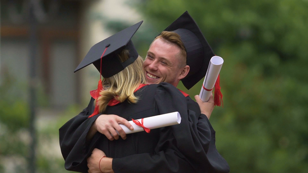 Graduados hombres y mujeres felices celebrando la graduación, abrazos, futuro feliz
 - Metraje, vídeo