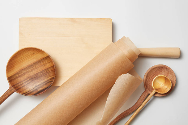roll baking paper and various wooden spoons - Photo, Image