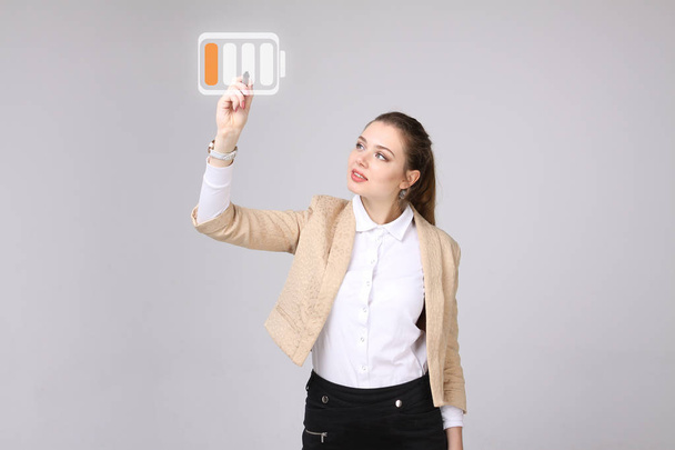 Young Businesswoman and battery level icon - Foto, imagen