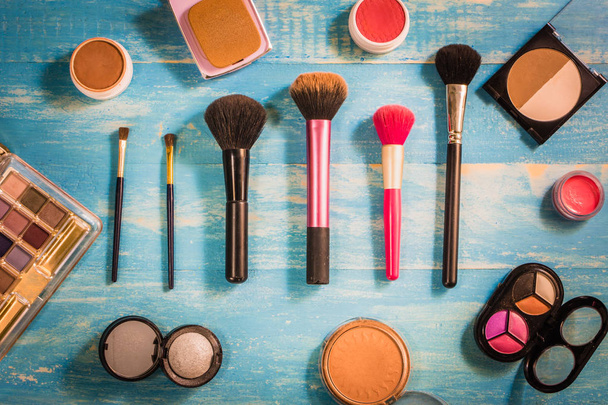 Pohled shora kosmetika make-up umístěné na dřevěný stůl - Fotografie, Obrázek