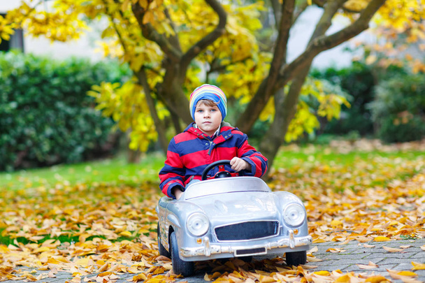 Pouco menino pré-escolar menino dirigindo brinquedo grande velho brinquedo vintage carro
 - Foto, Imagem