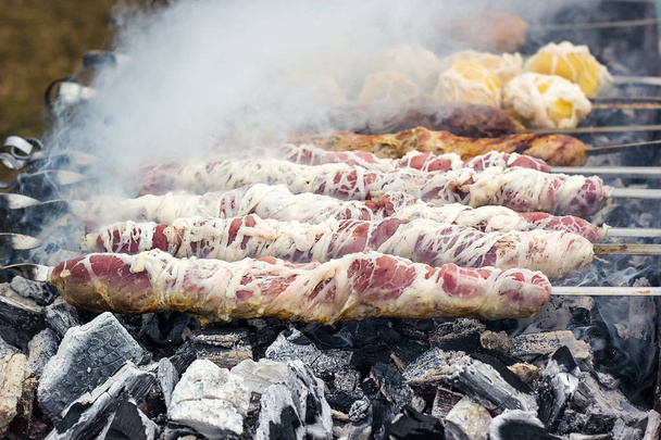 shashlik marinados preparándose en una parrilla de barbacoa sobre carbón vegetal. Shashlik o Shish kebab popular en Europa del Este. Shashlyk (carne pinchada) fue hecha originalmente de cordero. Kebabs de carne asada en parrilla de barbacoa. - Foto, Imagen