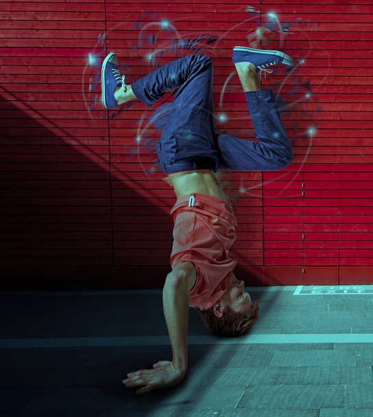 Break dancer doing handstand against colorful wall background - Φωτογραφία, εικόνα