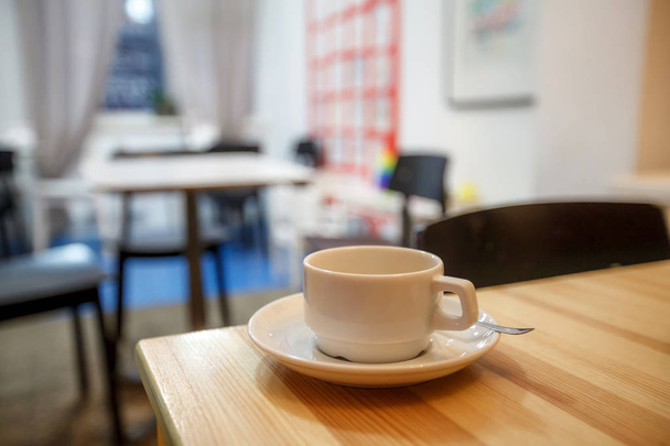 Kopje koffie in het café op de tafel, onscherpe achtergrond - Foto, afbeelding
