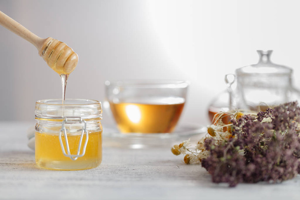 Honey in glass jar and honeycombs wax - Fotoğraf, Görsel
