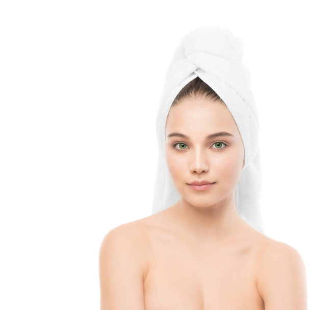 Mooie jonge brunette vrouw met schoon gezicht en handdoek op haar hoofd. Geïsoleerd. - Foto, afbeelding