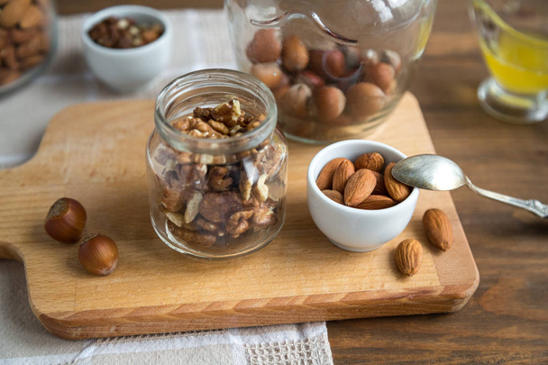 Assorted nuts: walnuts, almonds, hazelnuts and honey - Valokuva, kuva