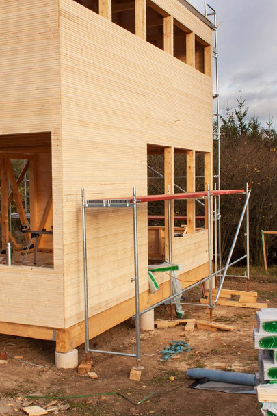 Bau eines ökologischen Hauses. Außenarbeiten an der Gebäudehülle. die Holzkonstruktion des Hauses in der Nähe des Waldes. - Foto, Bild