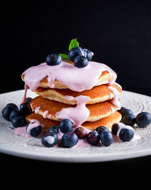 Pancakes with blueberries and yoghurt on white plate - Photo, Image