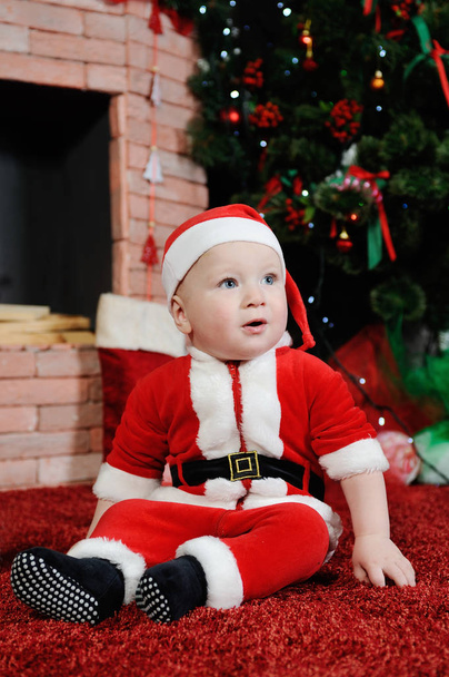 baby boy dressed as Santa Claus.  in a  suit on the back - Фото, изображение
