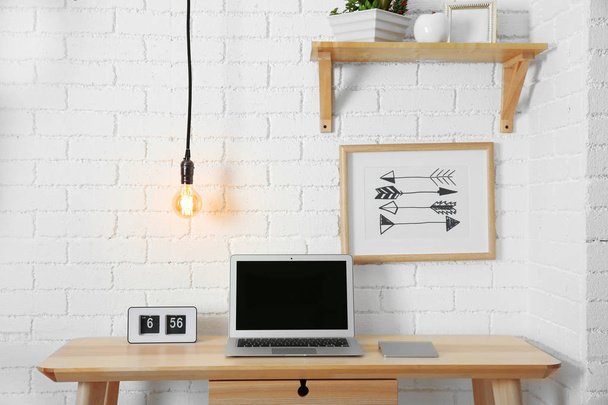 Work place interior design with light bulb on wire - Фото, изображение