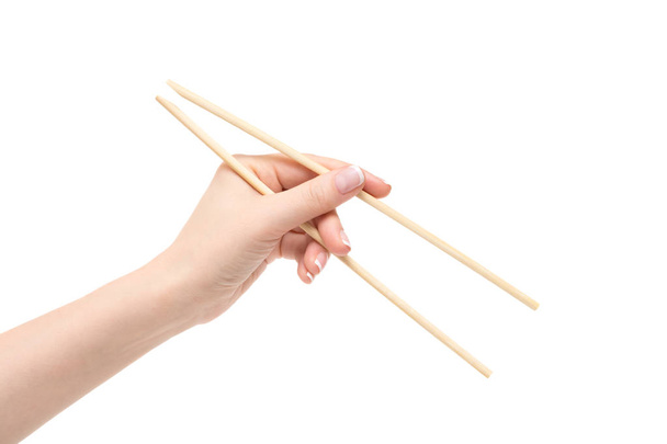 Female hand holds chopsticks on a white background. - Foto, imagen