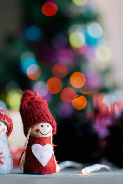 Twee gebreide poppen en een kopje koffie met Kerstmis achtergrond - Foto, afbeelding