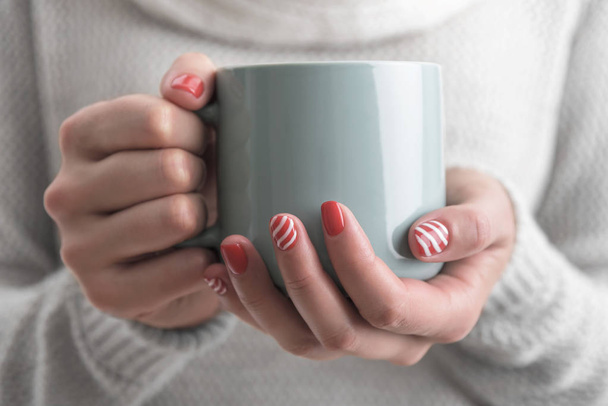 Womens hands holding a cup of drink. - Foto, afbeelding