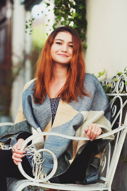Moda joven niña de 20 años sentada en el banco, con chaqueta de cuadros caliente
 - Foto, imagen