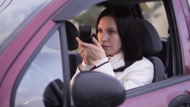 Woman applies makeup in the car - Filmati, video