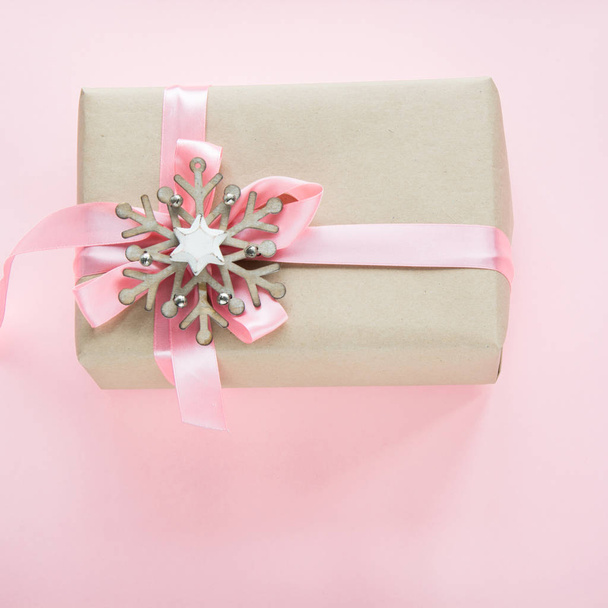 Christmas gift box for girl with pink ribbon and snowflakes on pink. Square image. - Фото, изображение