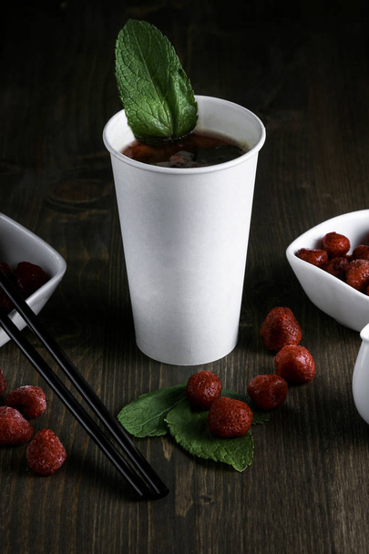 Drink in a white cup with strawberries and mint on a wooden background - Φωτογραφία, εικόνα
