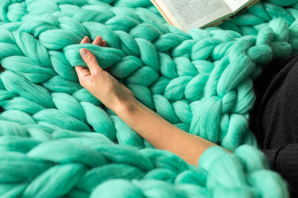 Cozy composition, closeup of woman reading book on merino wool p - Photo, Image