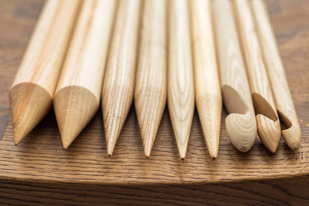 деревянные вязальные спицы на деревянном столе
 - Фото, изображение