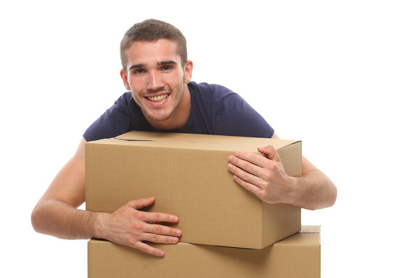 smiling young man with big boxes. on a white background. - 写真・画像