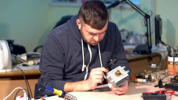 Hombre reparación de dispositivo roto en el taller
 - Imágenes, Vídeo