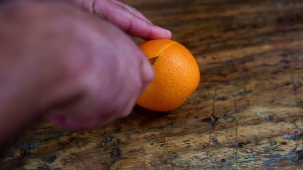 closeup of hand of man cutting an orange - Кадри, відео