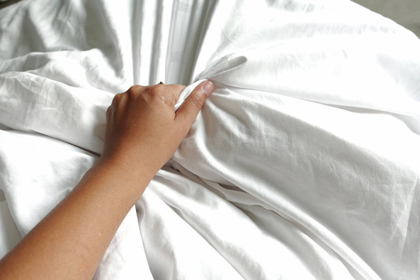 hand of women pulling white sheets in ecstasy, orgasm. - Valokuva, kuva