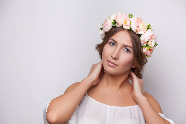 Beautiful girl in wreath of flowers studio shot - Foto, Imagem