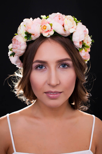 Beautiful girl in wreath of flowers closeup - Photo, image