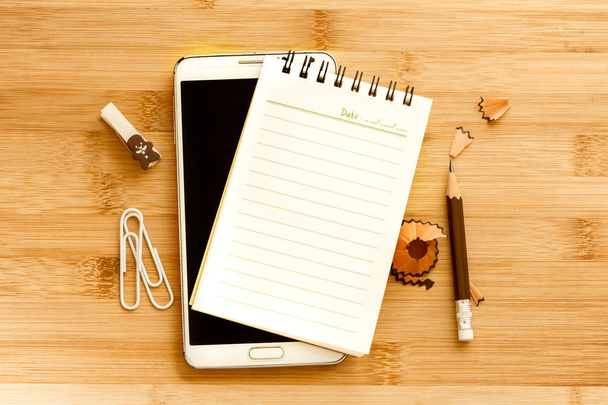 Blank notepad with  pencil and smart phone on wooden table  - Foto, Imagem