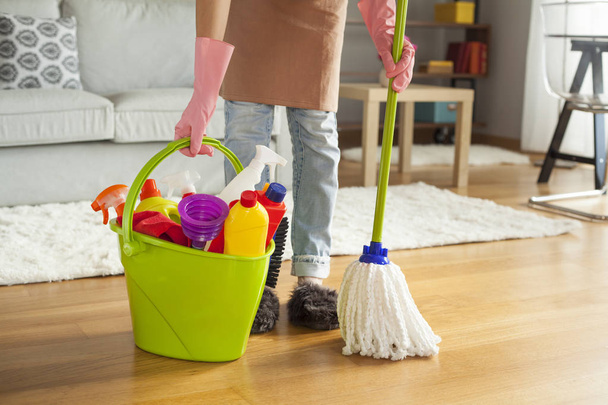 Young woman cleaning floor in room - Foto, imagen