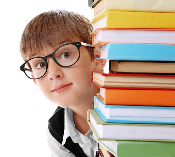 Cute schoolboy and heap of books on white background, closeup - Photo, Image
