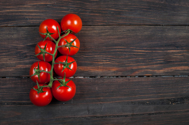Fresh cherry tomatoes on wood background. - Фото, изображение