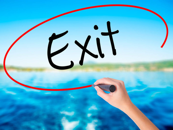 Woman Hand Writing Exit with a marker over transparent board - Photo, Image