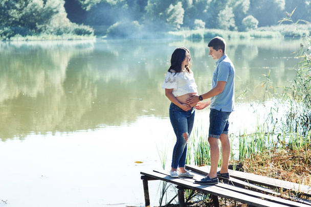 Man and pregnant woman near lake - Zdjęcie, obraz