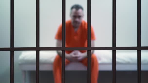 więzień człowiek siedzi w więzieniu - Materiał filmowy, wideo