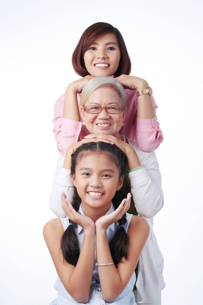 três gerações de mulheres sorrindo para a câmera
 - Foto, Imagem