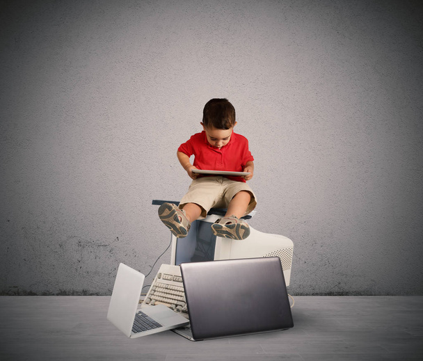 Child sitting on a pile of computers. - Photo, Image